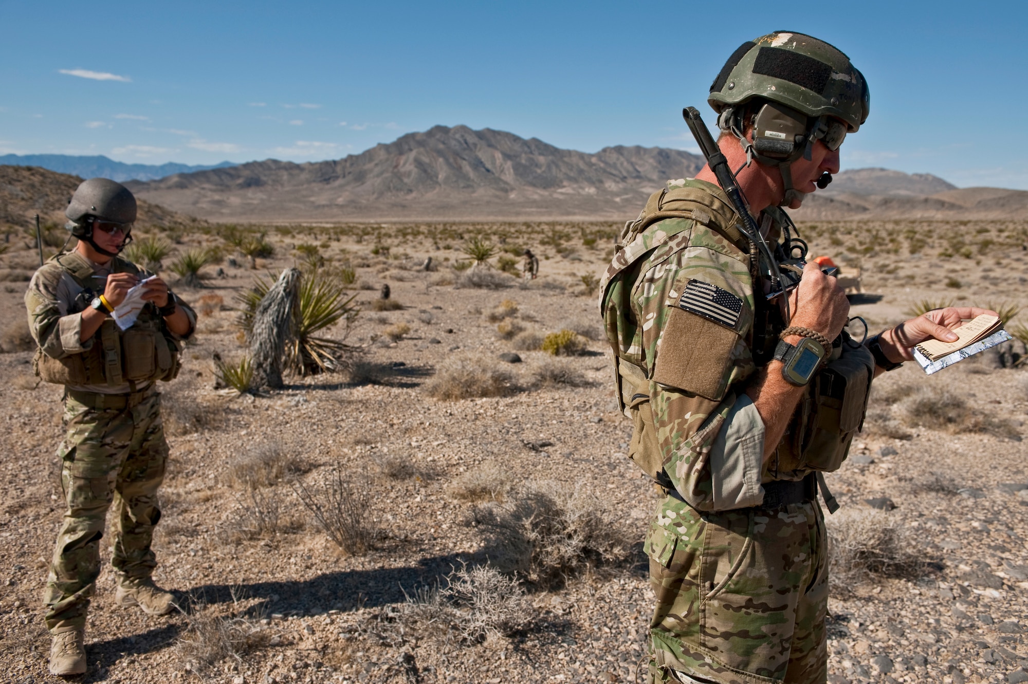 U.S. Air Force Senior Airman Corban Caliguire and Tech. Sgt. Aaron Switzer, 21st Special Tactics Squadron joint terminal attack controllers, from Pope Field, N.C., relay attack coordinates to inbound aircraft during a close air support training mission Sept. 23, 2011, at the Nevada Test and Training Range.  Joint Terminal Attack Controllers perform proficiency training with U.S. Air Force Weapons School students during the close air support phases of the Weapons School six-month, graduate-level instructor course. (U.S. Air Force photo by Tech. Sgt. Michael R. Holzworth/Released)