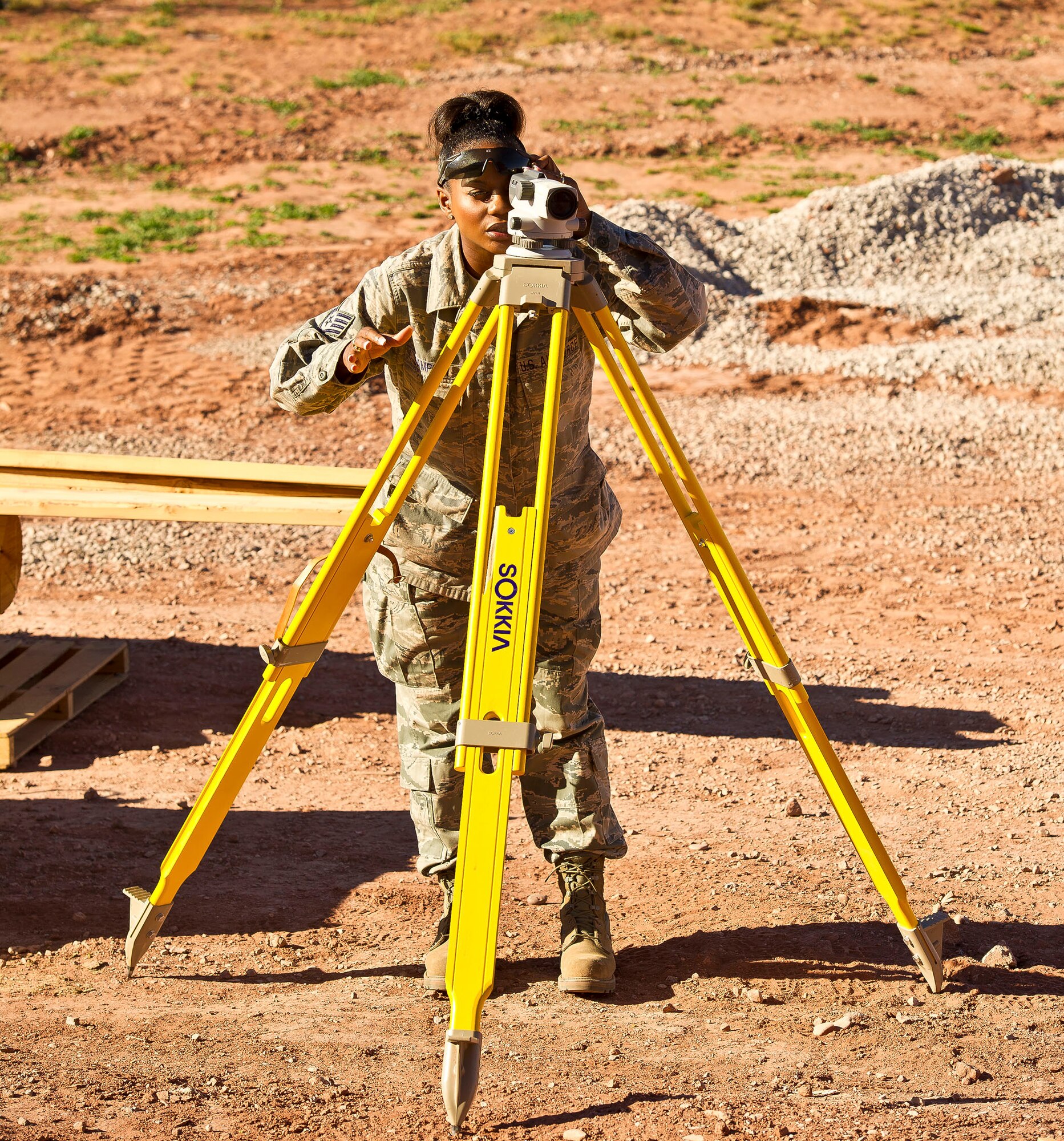 Staff Sgt. Tina Sampson, 116th Civil Engineering Squadron, Robins Air Force Base, Ga., uses an auto level to get an accurate measurement for construction of a new sidewalk  at St. Michaels Association for Special Education, Window Rock, Ariz., June 8, 2011.  Sampson, an Engineering Assistant, and more than 40 members of her squadron deployed to the Navajo Nation as part of the Department of Defense Innovative Readiness Training program. (U.S. Air Force photo by Master Sgt. Roger Parsons/Released)