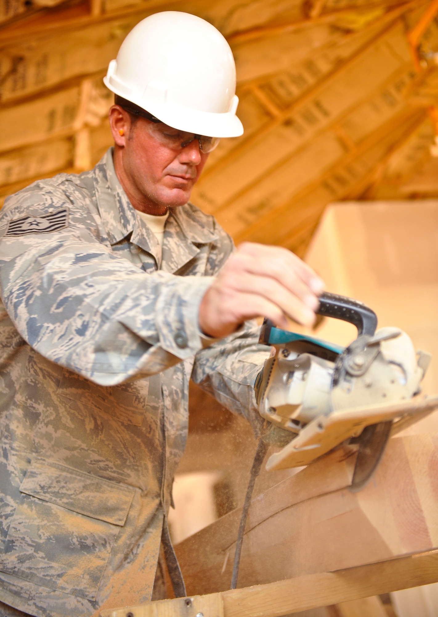 Tech. Sgt. Russell Hunt, 116th Civil Engineering Squadron, Robins Air Force Base, Ga., uses a circular saw to cut a ceiling beam for a renovation project at St. Michaels Association for Special Education, Window Rock, Ariz., June 6, 2011.  Hunt and more than 40 members of his squadron performed work for the Navajo Nation as a part of the Innovative Readiness Training program. (U.S. Air Force photo by Master Sgt. Roger Parsons/Released)