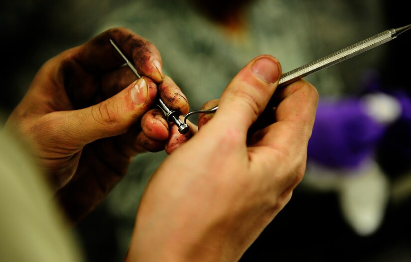 An Airman cleans the firing pin on an M-4 Carbine Sept. 7 at Joint Base Charleston-Air Base, during a Combat Arms Training and Maintenance qualifying course.  (U.S. Air Force photo/Airman 1st Class Matthew  Bruch)
