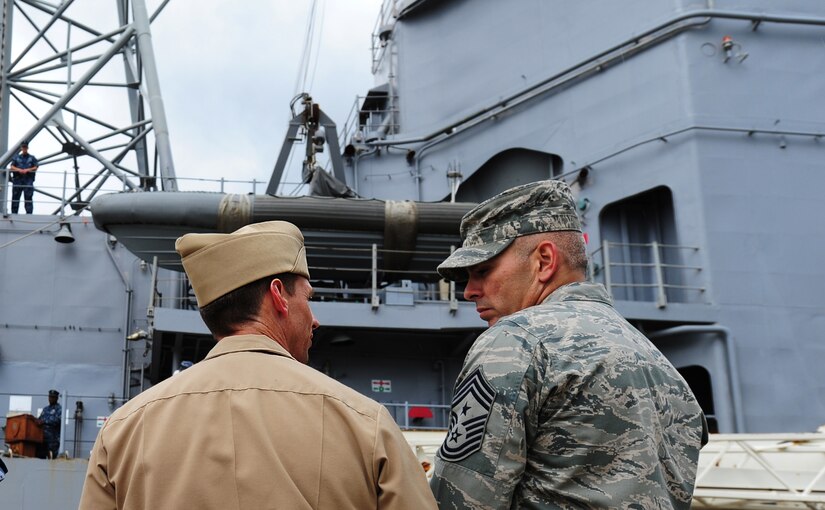 Master Chief Petty Officer  Billy Cady and Chief Master Sgt. Jose Lugo-Santiago discuss ship mooring procedures while the Guided-Missile Cruiser USS Vicksburg (CG 69) is guided pier-side, downtown Charleston, S.C, Sept. 23. The Vicksburg moored at the Columbus street terminal in the port of Charleston from Sept. 23 unitil Sept. 26. Cady is the Naval Support Activity command master chief and Lugo-Santiago is the Joint Base Charleston command chief. (U.S. Air Force photo/ Staff Sgt. Nicole Mickle) 


