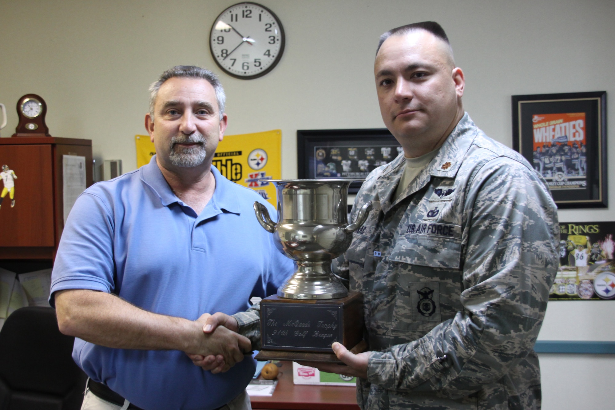 Ronald Piche, President of the 911th Golf League, awards Major John Bojanac, 911th Security Forces Squadron Commander, the McQuade Cup for winning the 2011 league championship, Sept. 16. (U.S. Air Force Photo/ Senior Airman Jonathan Hehnly)