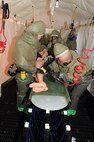 MINOT AIR FORCE BASE, N.D. -- Members of 5th Medical Group’s decontamination team execute cleaning procedures on a simulated patient during an exercise here Sept. 22. During the mass casualty exercise, personnel from the various factions of the 5th MDG responded setting up patient treatment areas throughout the entire medical building, each holding different responsibilities. The 5th MDG conducts exercises like these to test the readiness and effectiveness of medical contingency response plan procedures. (U.S. Air Force Photo/Airman 1st Class Jose L. Hernandez)
