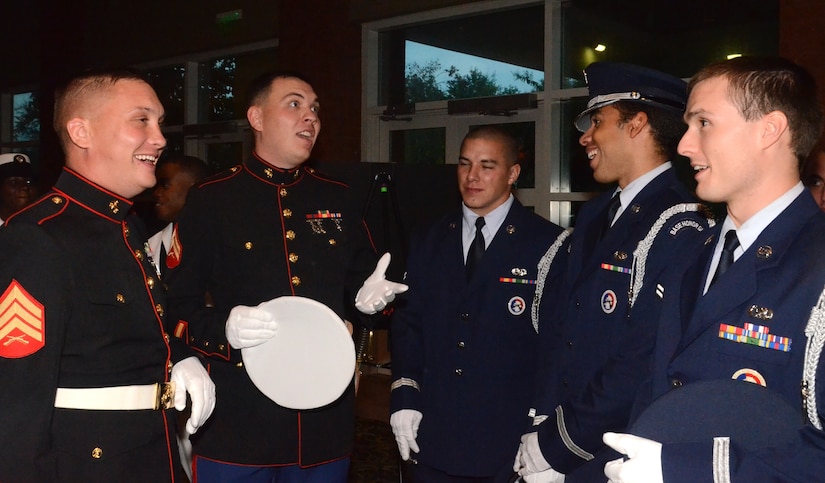 Marine Corps and Air Force members of the Joint Service Honor Guard share a laugh  before Posting the Colors for the Joint Base Charleston Military Ball Sept. 24. The Honor Guard, consisting of members from the Army, Navy, Marine Corps and Air Force, presented the colors while the Reasoner Family performed a traditional rendition of the National Anthem. (U.S. Air Force photo/2nd Lt. Susan Carlson)