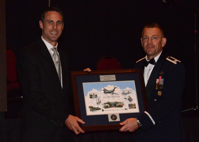 Joint Base Charleston Commander Col. Richard McComb presents a JB CHS coin and framed picture to guest speaker Coach Darrin Horn during the Joint Base Charleston Military Ball Sept. 24.  Horn is the University of South Carolina head basketball coach, and volunteered his time to be the guest speaker for the military ball. His speech related the diligence and sacrifice in the sports world with the sacrifice paid by every member wearing a uniform and by the spouses and families who support them.  More than 800 service members from across the joint base, encompassing the Army, Navy, Air Force and Marine Corps attended the military ball. (U.S. Air Force photo/2nd Lt. Susan Carlson)