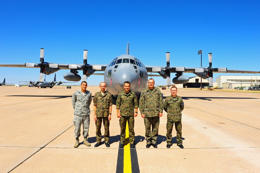 1st Lt. Edwin Cruz, 317th Maintenance Operations Squadron, stands outside a C-130 with Polish Air Force officers, Sept. 23, 2011, Dyess Air Force Base, Texas. Four Polish air force officers visited here to receive two weeks of fundamental maintenance and management skills training from 317th Maintenance Officers. (U.S. Air Force photo by Airman 1st Class Peter Thompson/Released)
