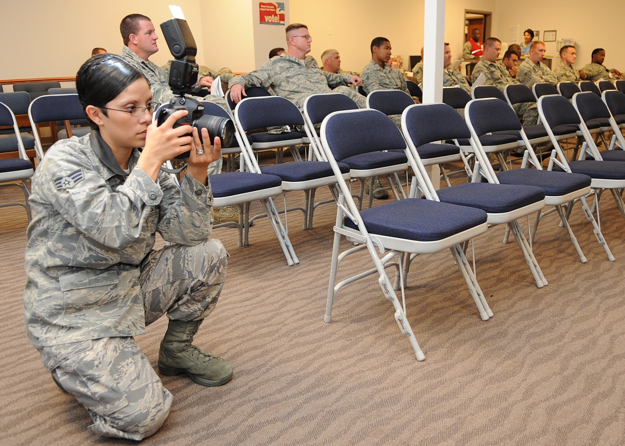 Senior Airman Maria Ruiz, 22nd Air Refueling Wing Public Affairs still photography journeyman, photographs an operational readiness exercise briefing at Building 1090 Sept. 26, 2011, McConnell Air Force Base, Kan. Ruiz’s responsibilities include photographing base events and official studio portraits, documenting crime scenes, writing journalistic stories to accompany photos and assisting in the training of new photographers.  (U.S. Air Force photo by Airman 1st Class Jose L. Leon)