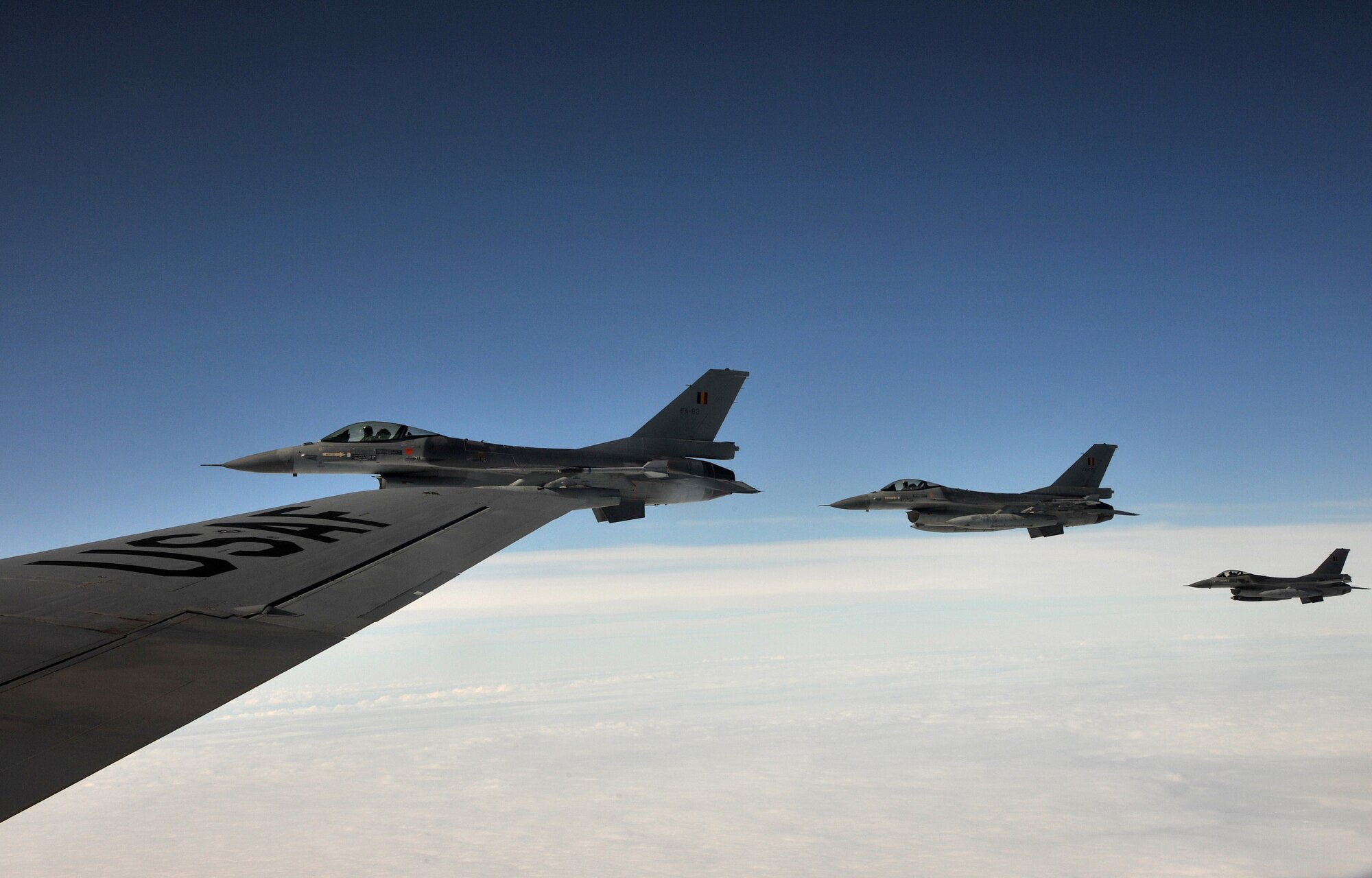 RAF MILDENHALL, England - Three Belgian F-16 Fighting Falcons sit at the tip of the wing of a KC-135 Stratotanker assigned to the 100th Air Refueling Wing over Germany Sept. 21, 2011. The F-16 participated in Exercise Brilliant Arrow, a multinational air exercise. Belgium, Germany, the United States and Turkey were among the participating nations. (U.S. Air Force photo by Senior Airman Jerilyn Quintanilla)  