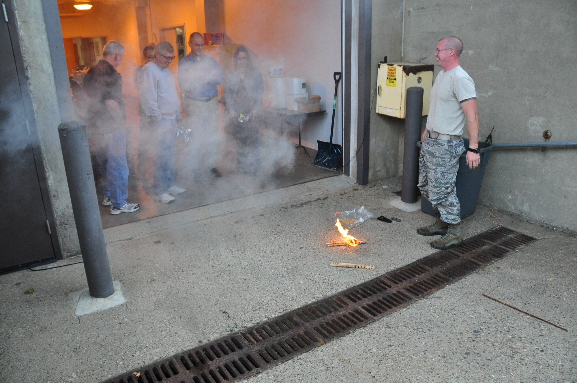 Staff Sgt. Adam Craft, 934th Airlift Wing Survival Evasion Rescue and Escape instructor, demonstrates starting a fire using only wood found in the wild for employees of Wings Financial Advisors during their tour Sept. 27. (Air Force Photo/Paul Zadach)
