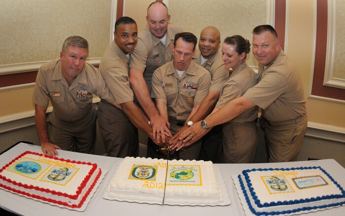 Master chief petty officers from Joint Base Charleston-Weapons Station cut a ceremonial cake with the newest, and youngest chief petty officer in attendance at the 2011 Khaki Ball, Chief Petty Officer Elizabeth Workman, who pinned on her anchors Sept. 16. The Khaki Ball, held Sept. 23, is a celebration welcoming this year's new chief petty officers into the Chief's Mess. Workman is a Machinist's Mate assigned to the Naval Nuclear Power Training Center at JB CHS - WS and has been in the Navy for six and a half years. (U.S. Navy photo/Mass Communication Specialist 1st Class Jennifer Hudson)