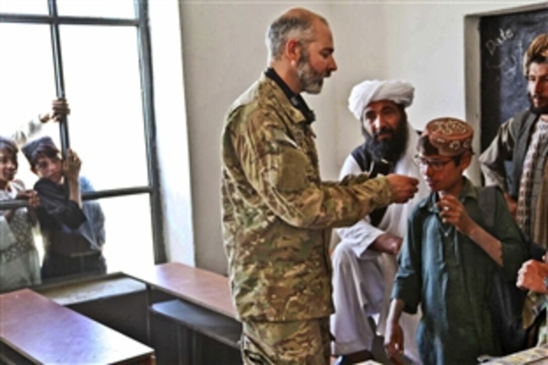 An Afghan man tries on a pair of test glasses with help from U.S. Army Lt. Col. Mark Reynolds during the village medical outreach program in Herat province, Afghanistan, Sept. 27, 2011. 