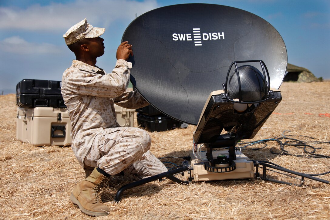 Corporal Garrett L. Spinks, satellite communications operator, communications section, 15th Marine Expeditionary Unit, puts the different pieces of the Support Wide Area Network mini version together at the unit’s field operation at Reconnaissance, Selection and Occupation of Position 95, Sept. 26-29. The training involved Marines from the MEU’s command element and their soon to be Battalion Landing Team - 3rd Battalion, 5th Marine Regiment, 1st Marine Division, Camp Pendleton, Calif. (U.S. Marine Corps photo by Cpl. John Robbart III)