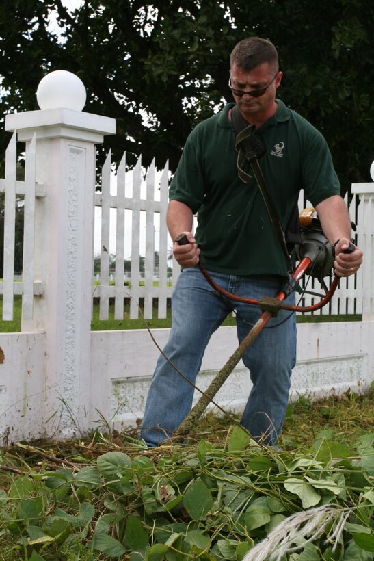 Master Sgt. James T. Wentling, Air Traffic Control staff noncommissioned officer in charge, uses a weed wacker to clear grass and other vegetation along the outside fence at Clark Veterans Cemetery Sept. 29. Wentling, along with 6 other master sergeants travelled to the Philippines last month to help clean up the cemetery.