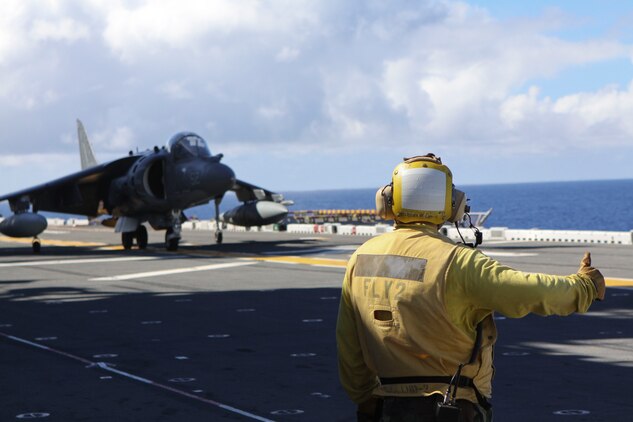 An Air Traffic Controller gives an AV-8B Harrier with Marine Attack Squadron 214, 31st Marine Expeditionary Unit, a thumbs up prior to take off aboard USS Essex, Sept. 29. The VMA was conducting this training in preparation for the MEU's Certification Exercise.