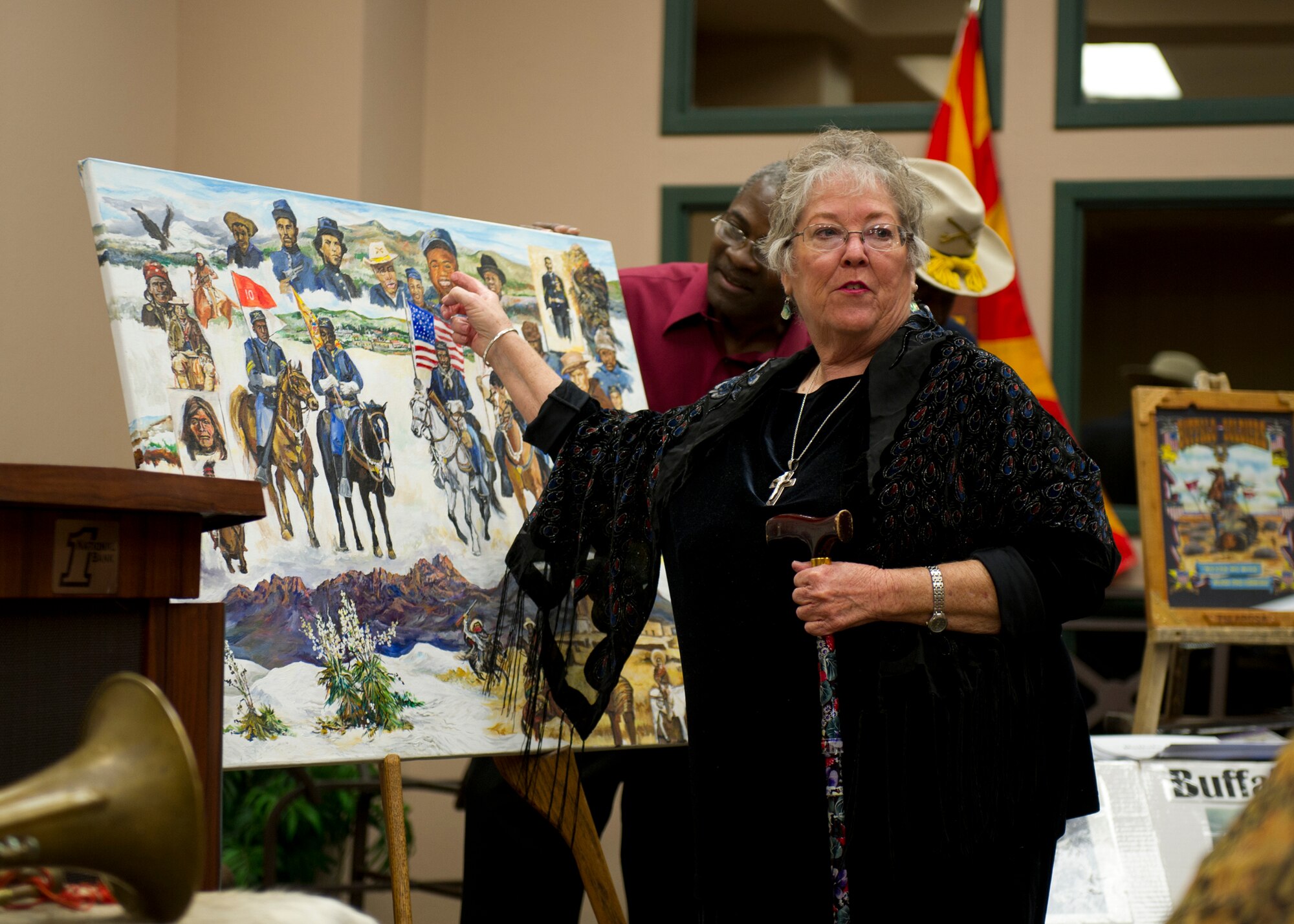 ALAMOGORDO, N.M. -- Kathy Hauge, an Otero County artist, describes details in the painting she dedicated to the Buffalo Soldiers and New Mexico historical landmarks such as White Sands National Monument and the Sacramento Mountains Sept. 27, 2011, at First National Bank. The painting will be hung on display at the bank temporarily, and then returned to Hauge. Members of the Buffalo Soldiers Society of New Mexico visited the area to educate people with real life Civil War artifacts, reenactments and brochure hand-outs for anyone interested. (U.S. Air Force photo by Airman 1st Class Eileen Meier/Released)