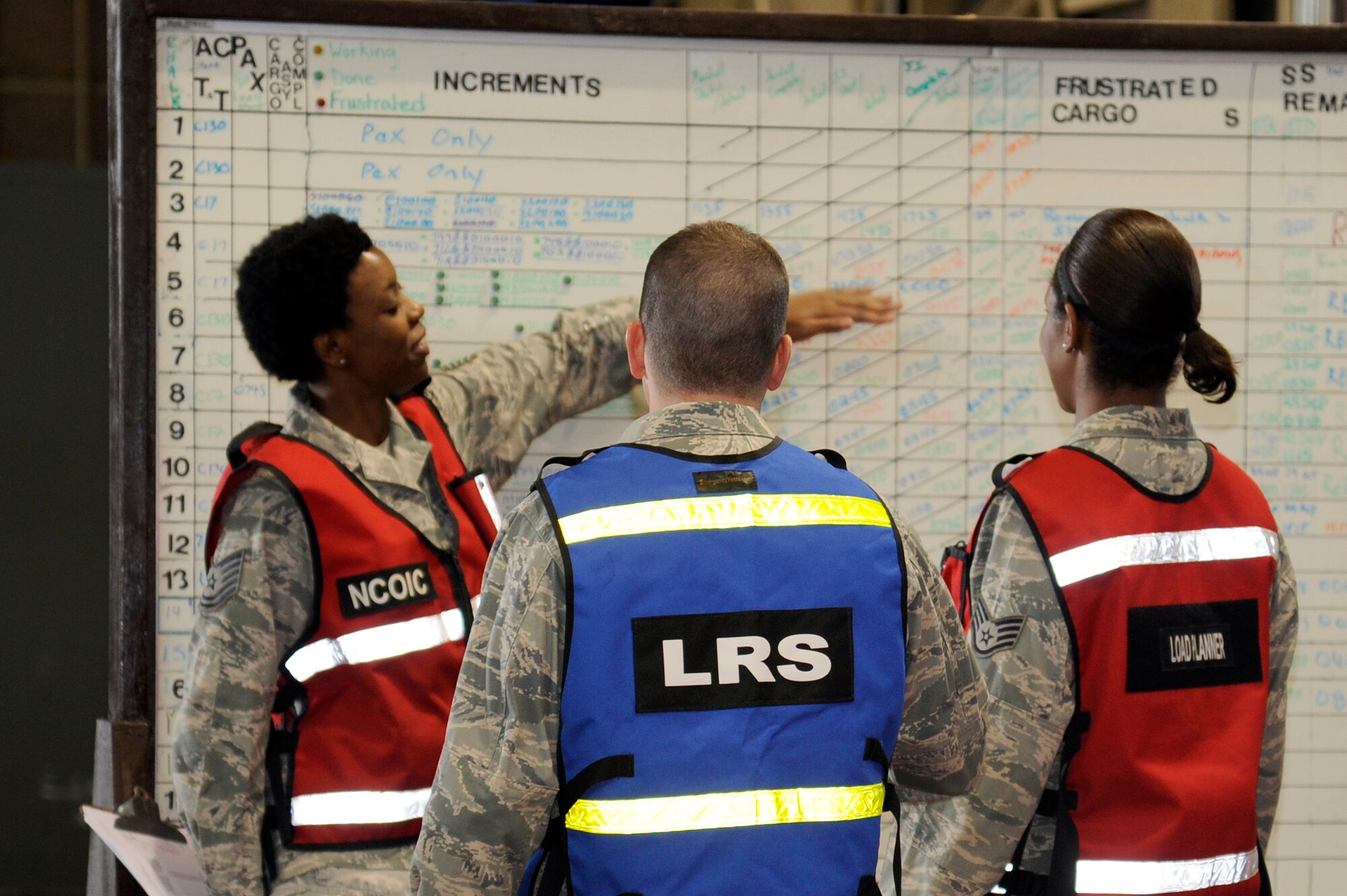 MISAWA AIR BASE, Japan - Tech. Sgt. LaJada Copeland, left,  shows Maj. Andrew Pate, center, and Staff Sgt. Mari Richardson, all from the 35th Logistics Readiness Squadron, the flow of cargo processing during an initial readiness response exercise here Sept. 29. The 35th Fighter Wing is currently going through an initial readiness response exercise to prepare for an upcoming operational readiness inspection this December. (U.S. Air Force photo/Tech. Sgt. Marie Brown)