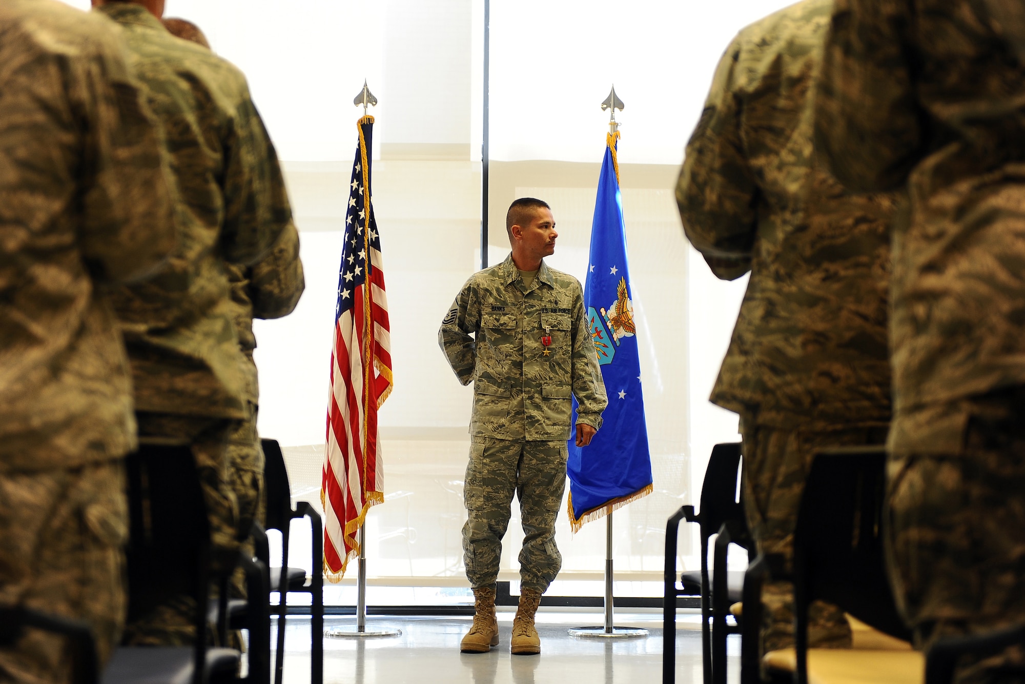 Colleagues were quick to leave their seats to applaud Master Sgt. Christopher Banks after he was formally presented the Bronze Star in the 55th Medical Group's dining facility on Offutt Air Force Base, Neb., Sept. 27. Banks received the Bronze Star for his acts of valor in response to an attack in Afghanistan. (U.S. Air Force photo by Josh Plueger/Released).