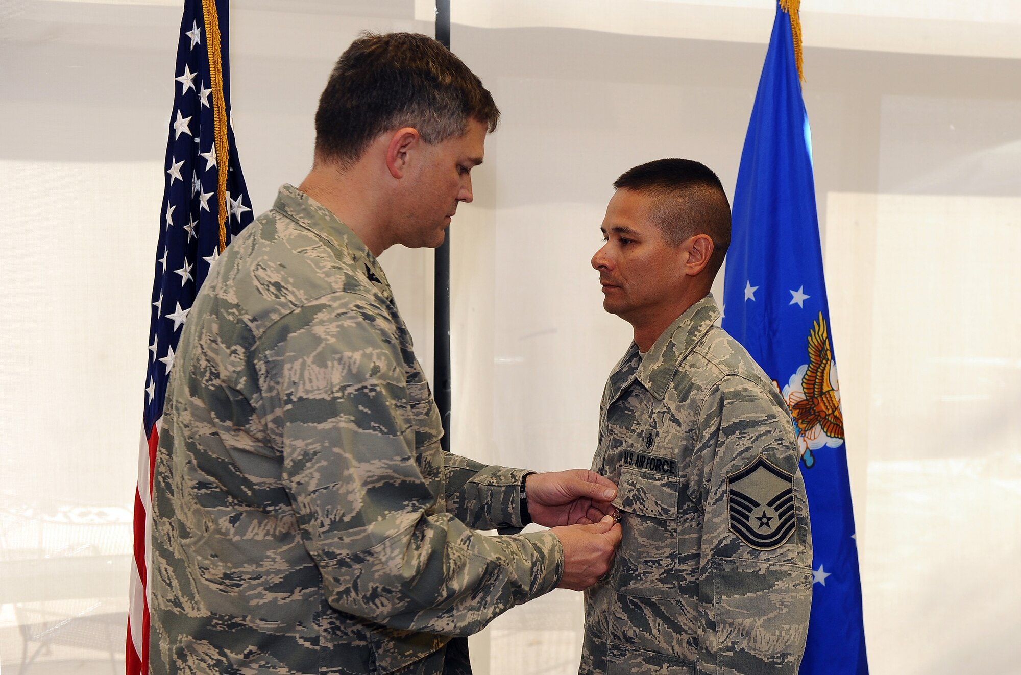 U.S. Air Force Col. Kevin D. Dixon, 55th Wing vice commander, pins the Bronze Star medal onto U.S. Air Force Master Sgt. Christopher Banks at a ceremony in the 55th Medical Group's dining facility, Offutt Air Force Base, Neb., Sept. 27. Banks earned the medal for his heroic acts performed under extreme real world conditions in Afghanistan. (U.S. Air Force photo by Josh Plueger/Released).