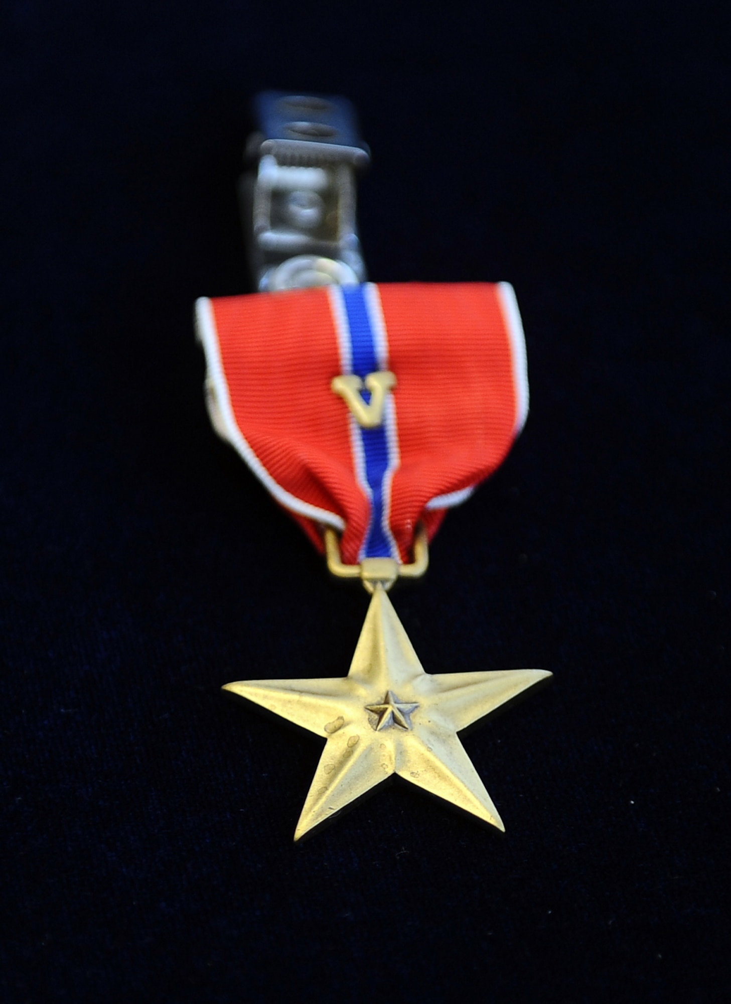 The Bronze Star medal is a U.S. armed forces military decoration that is awarded to an individual for bravery, acts of merit or meritorious service. The "V" device located on the ribbon indicates valor and is added to the medal to denote heroism. (U.S. Air Force photo by Josh Plueger/Released).