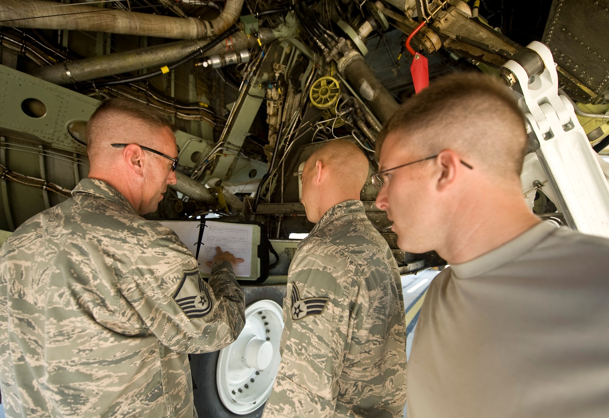 Airmen from the 2nd Aircraft Maintenance Squadron review maintenance logs in the wheel well of a B-52H Stratofortress on Barksdale Air Force Base, La., Sept. 29. The B-52 fleet is continually maintained to ensure the bombers are mission ready at a moment's notice. (U.S. Air Force photo/Senior Airman Chad Warren)(RELEASED)