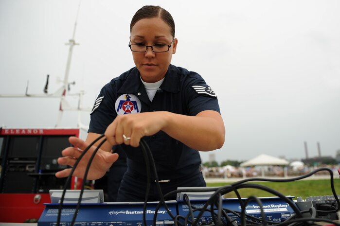 Staff Sgt. Jennifer Emerson, a client support administrator, installs cables to the music production equipment at the Cleveland National Air Show, Sept. 4, 2011.(U.S. Air Force photo/Staff Sgt. Larry E. Reid Jr., Released)