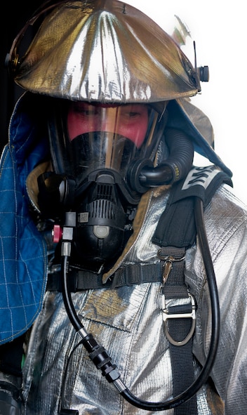 U.S. Air Force Airman 1st Class Donald Carey, 23rd Civil Engineer Squadron firefighter, looks back at his wingman as he goes through the steps of putting out a fire during a phase II operational readiness exercise at Moody Air Force Base, Ga., Sept. 29, 2011. Carey hosed down the building while his wingman kept communication with his chief and the rest of the firefighters. (U.S. Air Force photo by Senior Airman Stephanie Mancha/Released)   