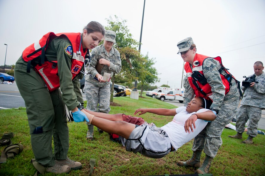 U.S. Air Force Capt. Susan Marchiano, 347th Operations Support Squadron flight surgeon, and Senior Airman Jennifer Lewis, 23rd Aerospace Medicine Squadron medical technician, lifts Senior Airman Shatavia Wallace, 824th Base Defense Squadron fireteam member, to transport on a litter during a mass casualty exercise Sept. 23, 2011, at Moody Air Force Base, Ga. Medics from the 23rd Wing and 93d Air Ground Operations Wing came together to participate in the exercise and treat patients. (U.S. Air Force photo by Staff Sgt. Jamal D. Sutter/Released) 