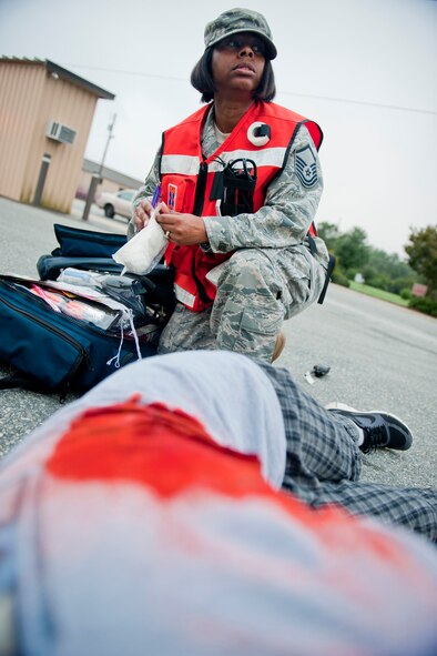 U.S. Air Force Master Sgt. Kimberly Robinson, 23rd Aerospace Medicine Squadron flight medicine NCO in charge, prepares to treat a victim during a mass casualty exercise Sept. 23, 2011, at Moody Air Force Base, Ga. The exercise simulated a car bomb explosion which wounded and killed more than 20 victims. Medics were evaluated on their ability to respond, treat and stabilize patients as they would during a real-world situation. (U.S. Air Force photo by Staff Sgt. Jamal D. Sutter/Released)