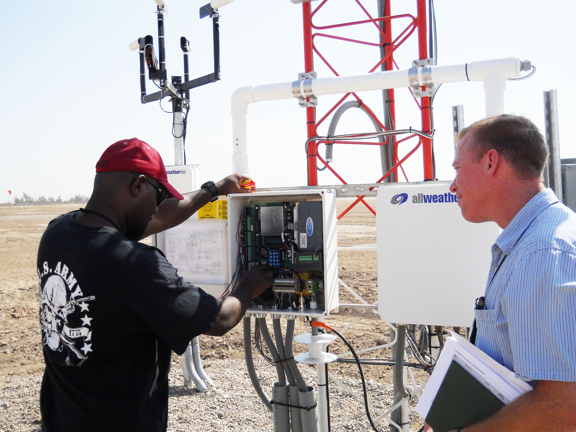Rainy McIntosh (right), Foreign Military Sales program manager, and Andre
Thrailkill, Taji Air Base site lead, perform a final checkout in
September of the Airfield Meteorological Observation System installed at
Taji Airbase, Iraq. The AMOS provides real-time temperature, wind,
precipitation, lightning indication and other meteorological information to
air traffic controllers. The Electronic Systems Center recently completed
FMS efforts that improve and upgrade Iraq's air traffic control system.
(Courtesy photo)
