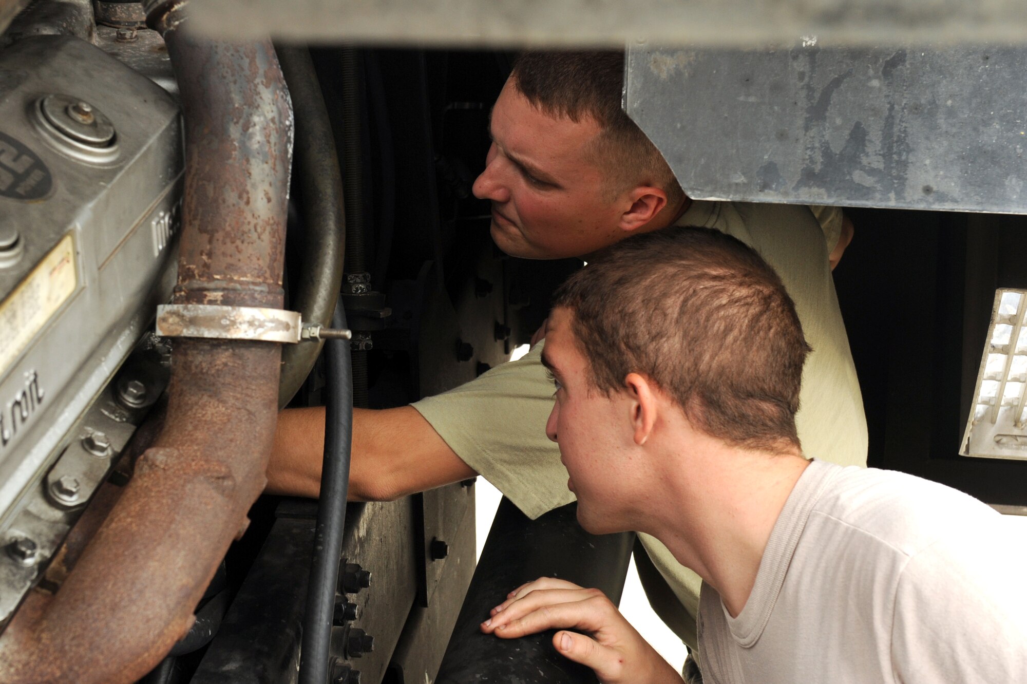 Staff Sgt. Tyler Gardner and Airman 1st Class Jason Birdsong (front) inspect the belt on an engine during a routine weekly inspection at Seymour Johnson Air Force Base, N.C., Sept. 27, 2011. Fire truck maintainers are the only Airmen authorized to work on military fire trucks and are required to have a minimum of two trucks serviceable at all times. Gardner and Birdsong are both 4th Logistics Readiness Squadron fire truck maintainers. Birdsong is a native of Thomaston, Ga. and Gardner is a native of Haleyville, Ala. (U.S. Air Force photo by Senior Airman Whitney Stanfield)
