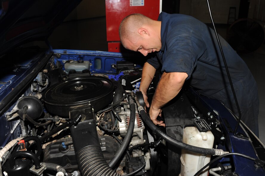 Senior Airman Brian Ball connects a vehicle fan to a stud during a maintenance repair at Seymour Johnson Air Force Base, N.C., Sept. 27, 2011. Without a fan inside of a shroud the radiator could overheat and possibly blow the motor. Ball is a 4th Logistics Readiness Squadron vehicle mechanic technician and a native of Carning, N.Y.   (U.S. Air Force photo by Senior Airman Whitney Stanfield)