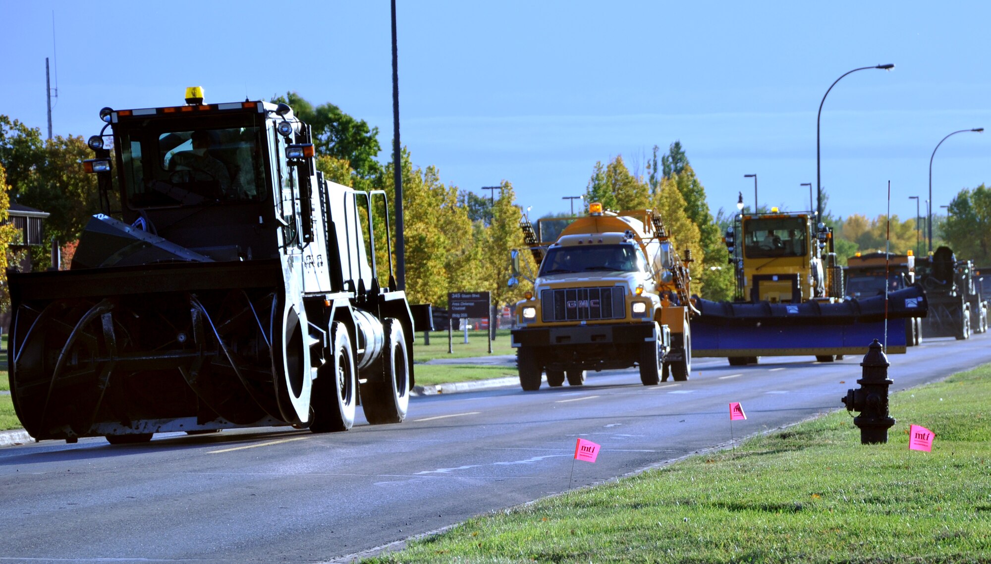 Snow removal equipment vehicles cruise along during the Snow Removal Equipment Parade on Grand Forks Air Force Base Sept. 29. This year there were 18 snow removal equipment vehicles that participated in the parade which allowed base personnel to see the equipment before the first snow fall. (U.S. Air Force photo by Airman 1st Class Derek VanHorn)