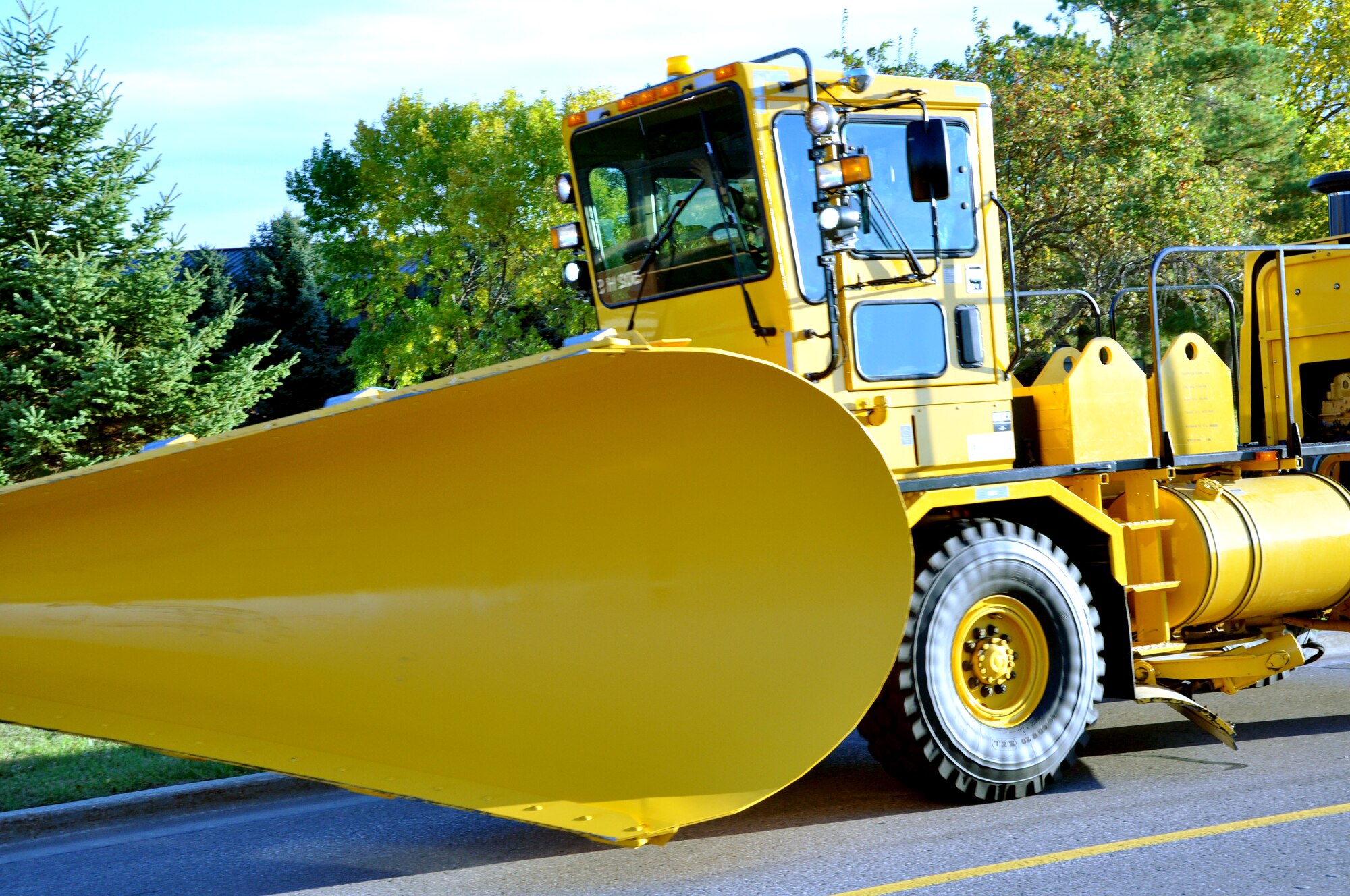 Snow removal equipment vehicles cruise along during the Snow Removal Equipment Parade on Grand Forks Air Force Base Sept. 29. This year there were 18 snow removal equipment vehicles that participated in the parade which allowed base personnel to see the equipment before the first snow fall. (U.S. Air Force photo by Airman 1st Class Derek VanHorn)