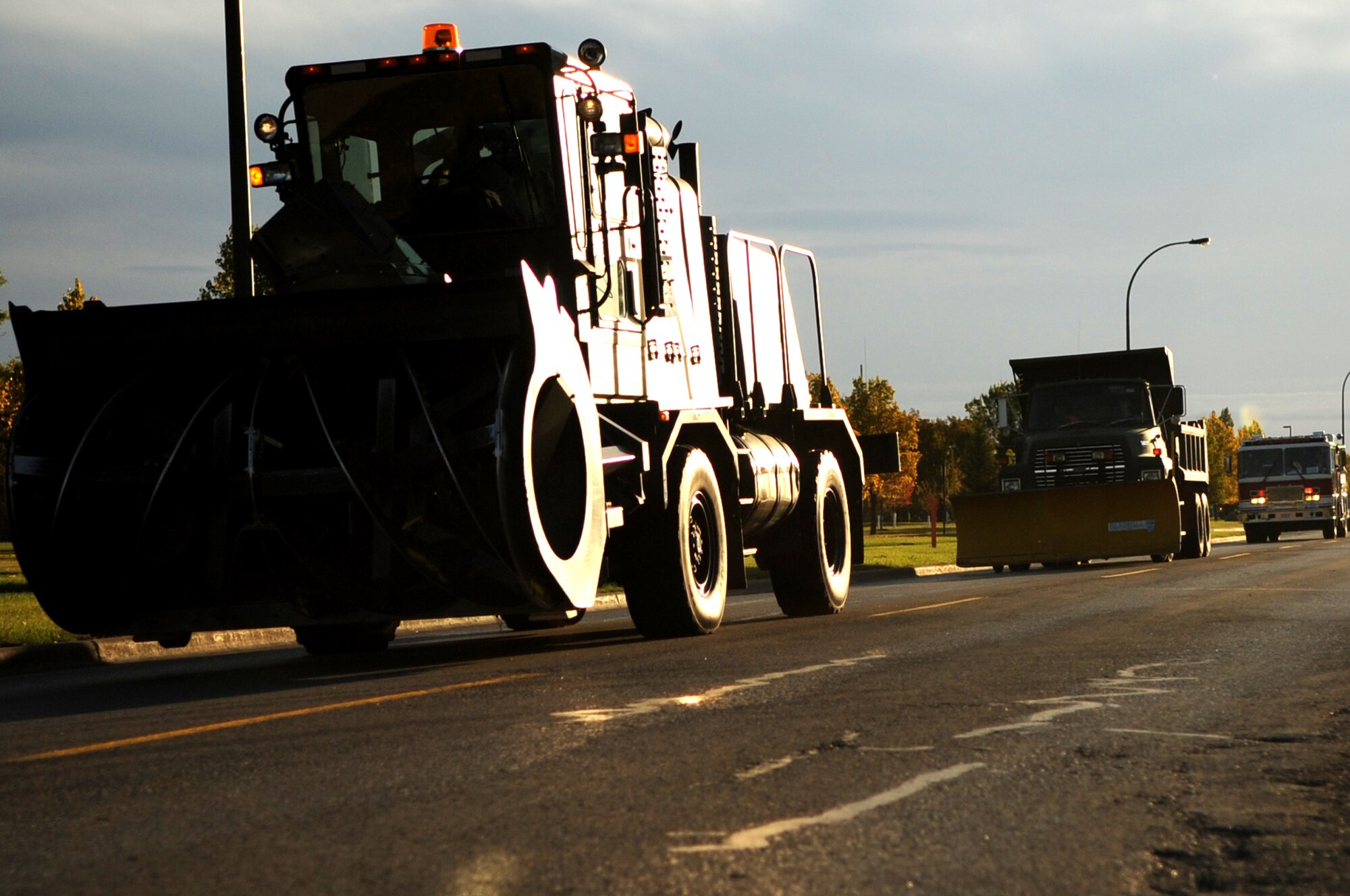 Snow removal equipment vehicles cruise along during the Snow Removal Equipment Parade on Grand Forks Air Force Base Sept. 29. This year there were 18 snow removal equipment vehicles that participated in the parade which allowed base personnel to see the equipment before the first snow fall. (U.S. Air Force photo by Senior Airman Amanda N. Stencil)