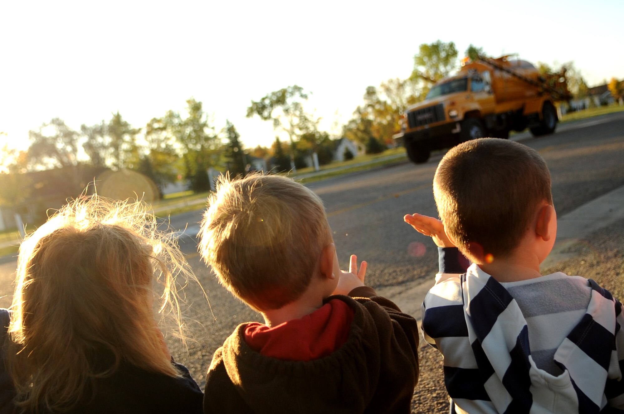 Children from the Child Development Center wave during the Snow Removal Equipment Parade on Grand Forks Air Force Base Sept. 29. This year there were 18 snow removal equipment vehicles that participated in the parade which allowed base personnel to see the equipment before the first snow fall. (U.S. Air Force photo by Senior Airman Amanda N. Stencil)