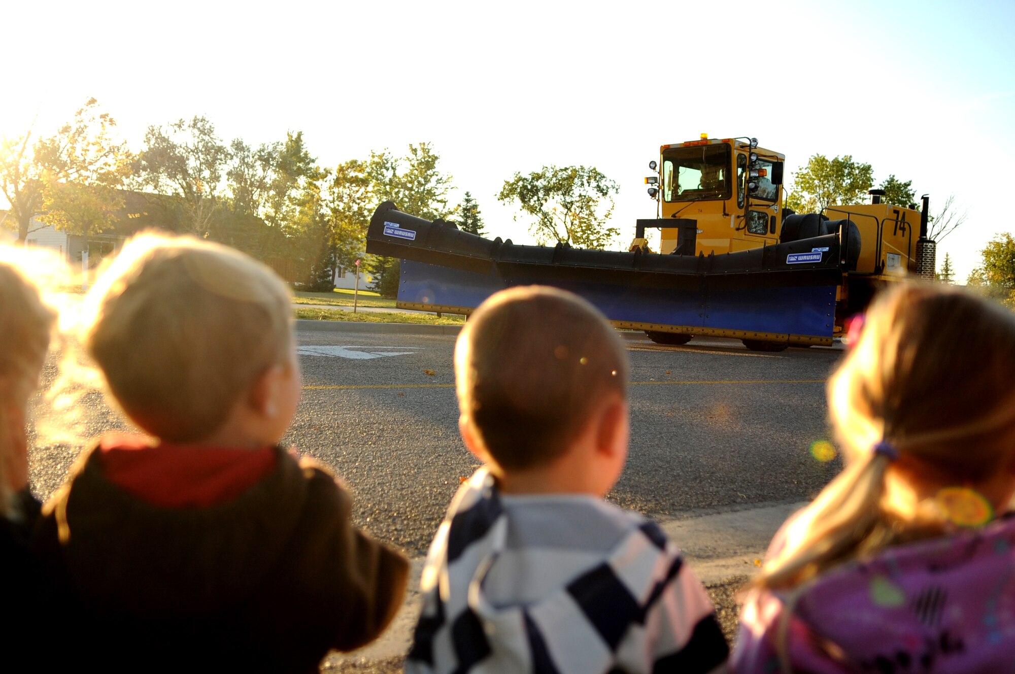 Children from the Child Development Center watch as the Snow Removal Equipment Parade goes by on Grand Forks Air Force Base Sept. 29. This year there were 18 snow removal equipment vehicles that participated in the parade which allowed base personnel to see the equipment before the first snow fall. (U.S. Air Force photo by Senior Airman Amanda N. Stencil)