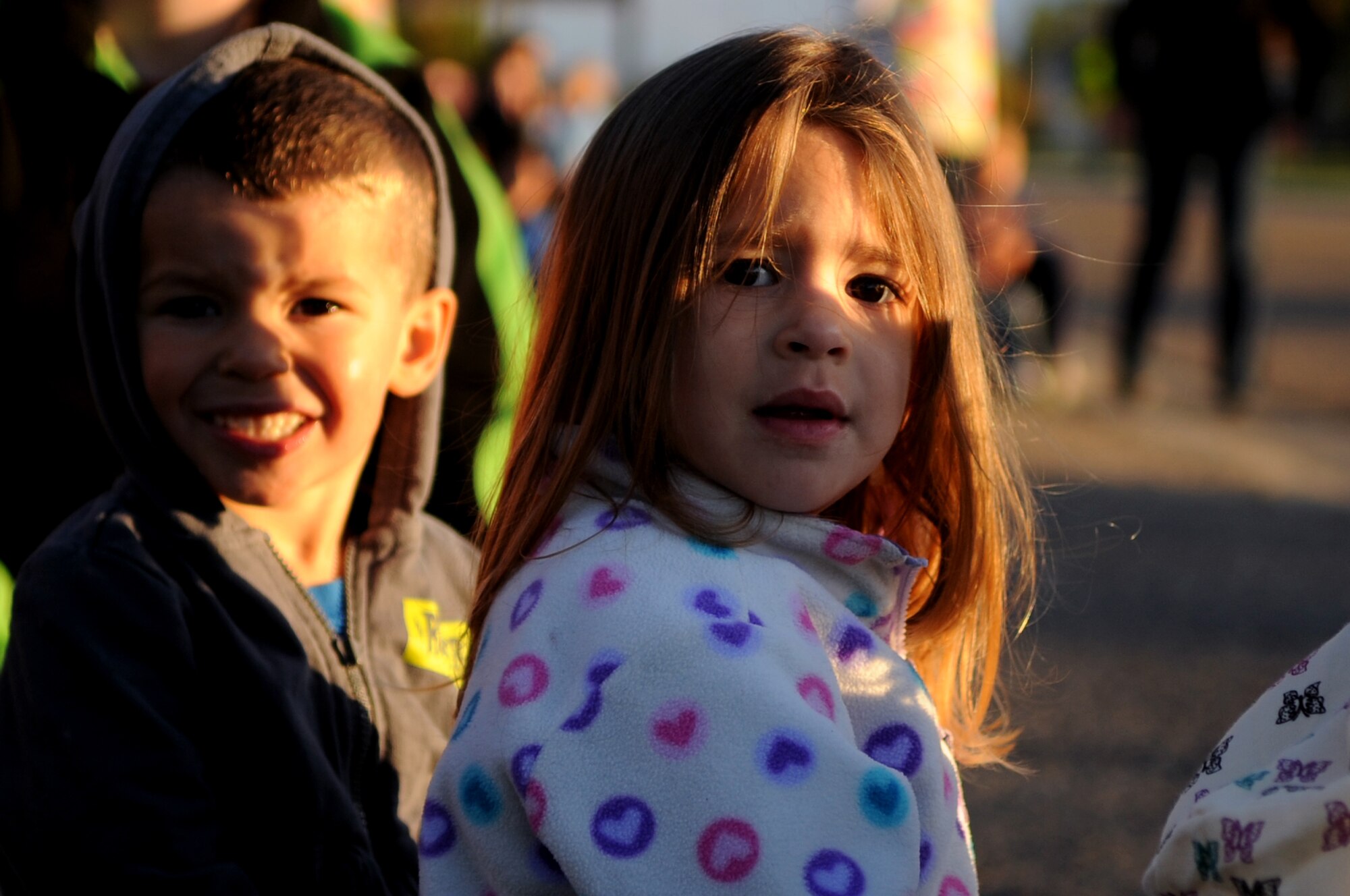 Children from the Child Development Center look onward for the beginning of the Snow Removal Equipment Parade on Grand Forks Air Force Base Sept 29. This year there were 18 snow removal equipment vehicles that participated in the parade which allowed base personnel to see the equipment before the first snow fall. (U.S. Air Force photo by Senior Airman Amanda N. Stencil)