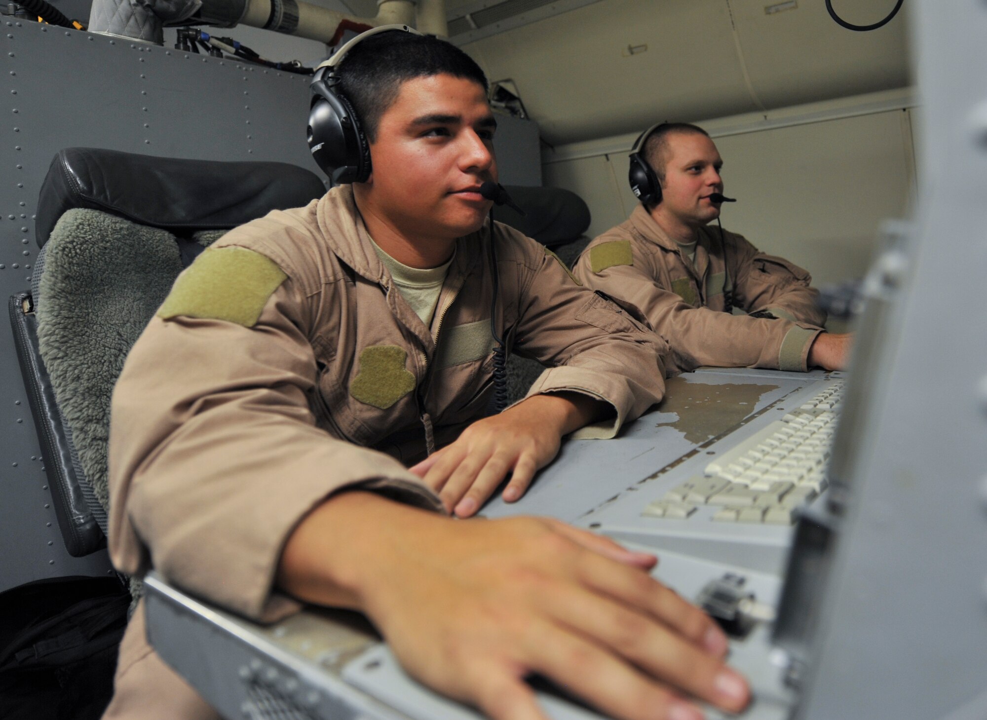 Airman 1st Class Daniel Martinez (left) and Airman 1st Class Jeffrey Slovik, 7th Expeditionary Airborne Command and Control Squadron air operations technicians, track and report suspicious activity on the ground, aboard an E-8C Joint Surveillance Target Attack Radar System, or Joint STARS, Sept. 25, 2011, at an undisclosed location in Southwest Asia. (U.S. Air Force photo/Senior Airman Paul Labbe)
