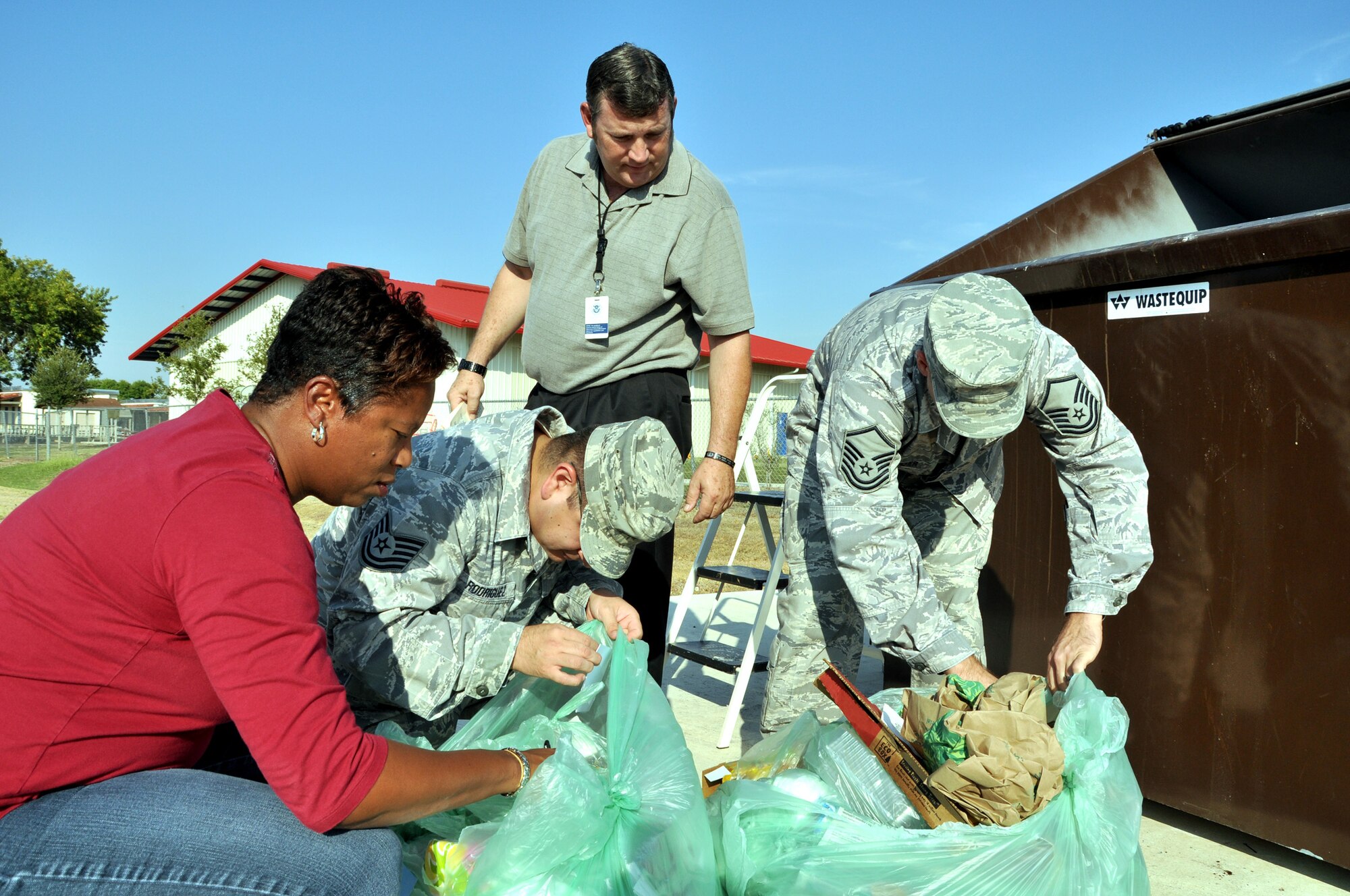 (Standing) Dr. Jim Crissinger, Air Education and Training Command program manager for critical asset risk management and operations security programs, and his inspection team of (from left) Cathey Green, Tech. Sgt. Juan Rodriguez and Master Sgt. Donald Alexander inspect trash pulled from a dumpster for operations security violations. In the few bags of trash the team inspected, three security violations were found. (U.S. Air Force photo/Staff Sgt. Clinton Atkins)
