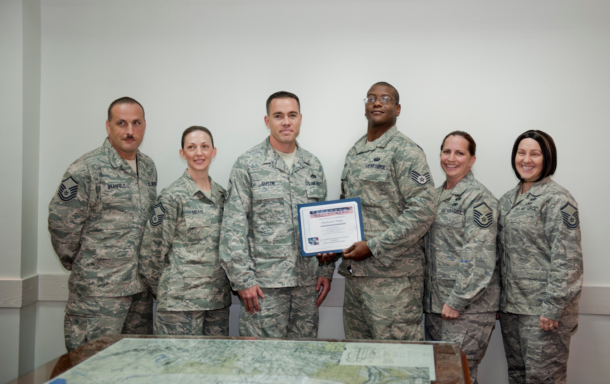 Staff Sgt. Kevin Pender, 728th Air Mobility Squadron client systems technician, receives the Unsung Hero Award from members of the Incirlik Top 3 Sept. 28, 2011, at Incirlik Air Base, Turkey. Pender received the award for single-handedly fixing the vital radio frequency identification tag interrogator, the Department of Defense’s cargo-tracking system, with 100 percent in-transit visibility. (U.S. Air Force photo by Senior Airman Anthony Sanchelli/Released)