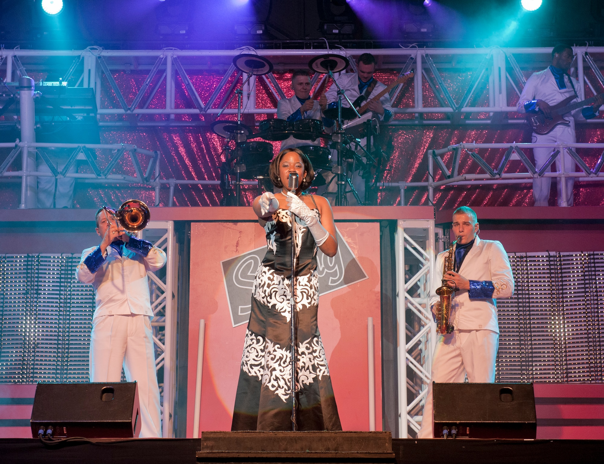 Senior Airman Patrice Brown, Tops in Blue vocalist, center, sings during a performance Sept. 27, 2011, at Incirlik Air Base, Turkey. Tops in Blue serves as an expeditionary entertainment unit that provides quality entertainment from within Air Force resources for the Air Force family. The group promotes community relations, supports recruiting efforts, and serves as ambassadors for the U.S. and the Air Force. (U.S. Air Force photo by Senior Airman Anthony Sanchelli/Released)