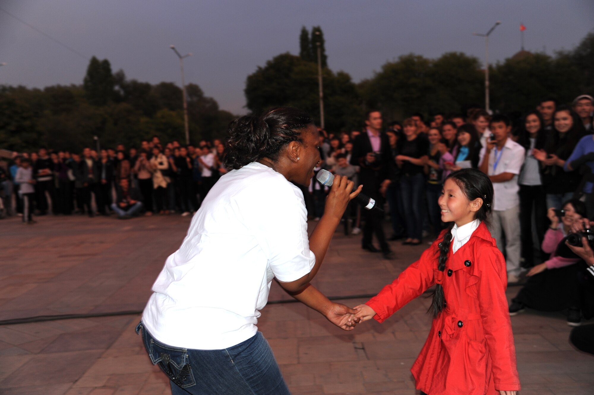 Staff Sgt. Amber Grimes dances with a child during a “Top Cover” performance at A’la Too Square in Bishkek, Kyrgyzstan, Sept. 23. The U.S. Air Forces Central Command band Top Cover visited the Kyrgyz Republic to help build troop morale and public diplomacy. Grimes is a vocalist deployed from Joint Base Elmendorf-Richardson, Alaska. (U.S. Air Force photo/Tech. Sgt. Hank Hoegen)