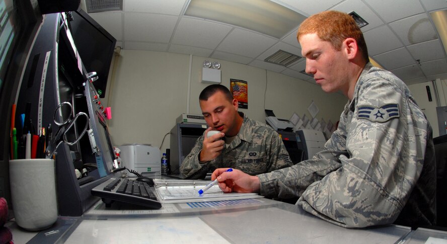 Staff Sgt. Dominick Streeter and Senior Airman Shawn Steele, both 8th Fighter Wing command post controllers, work together as they practice their “Giant Voice” skills at Kunsan Air Base, Republic of Korea, Sept. 28, 2011. The command post is a mission essential office with 12-hour shifts for 24-hour operations. This office, a wing staff agency, is known as the eyes, ears and voice of the wing commander. (U.S. Air Force photo by Senior Airman Benjamin Stratton/Released)