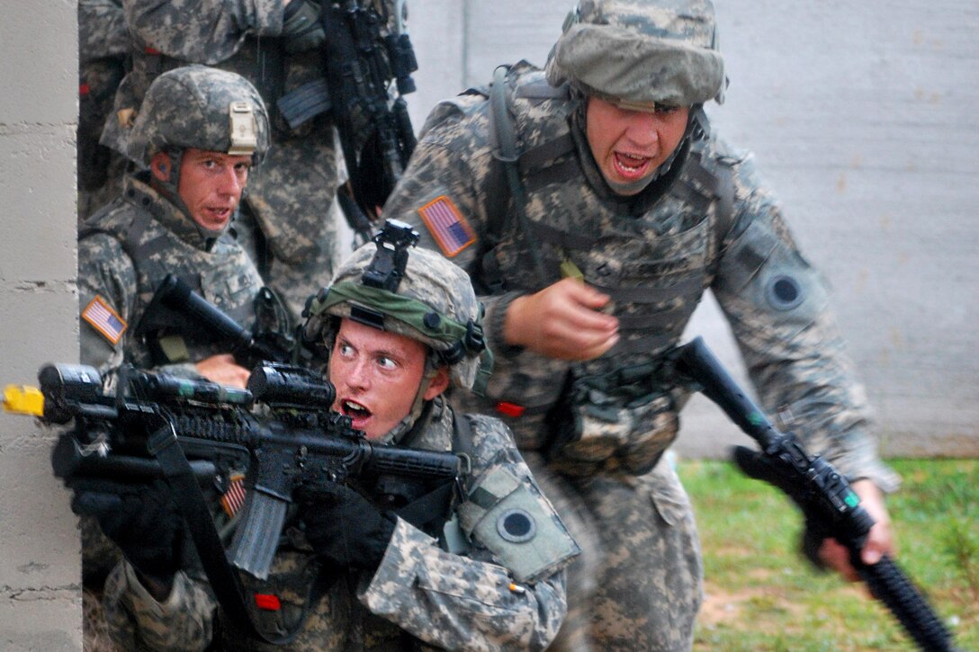U.S. Army Pfc. Christopher M. Nolan watches as Spc. Kipp M. Young lays cover fire for Pfc. Andrew R. Sieving, as he sprints to the next covered position during the urban operations portion of premobilization training at Camp Shelby Joint Forces Training Center, Miss., Sept. 28, 2011. Nolan, Young and Sieving are assigned to C Company, 1st Battalion, 148 Infantry Regiment, 37th Infantry Brigade Combat Team. The unit is preparing to deploy approximately 3,400 soldiers to Afghanistan.