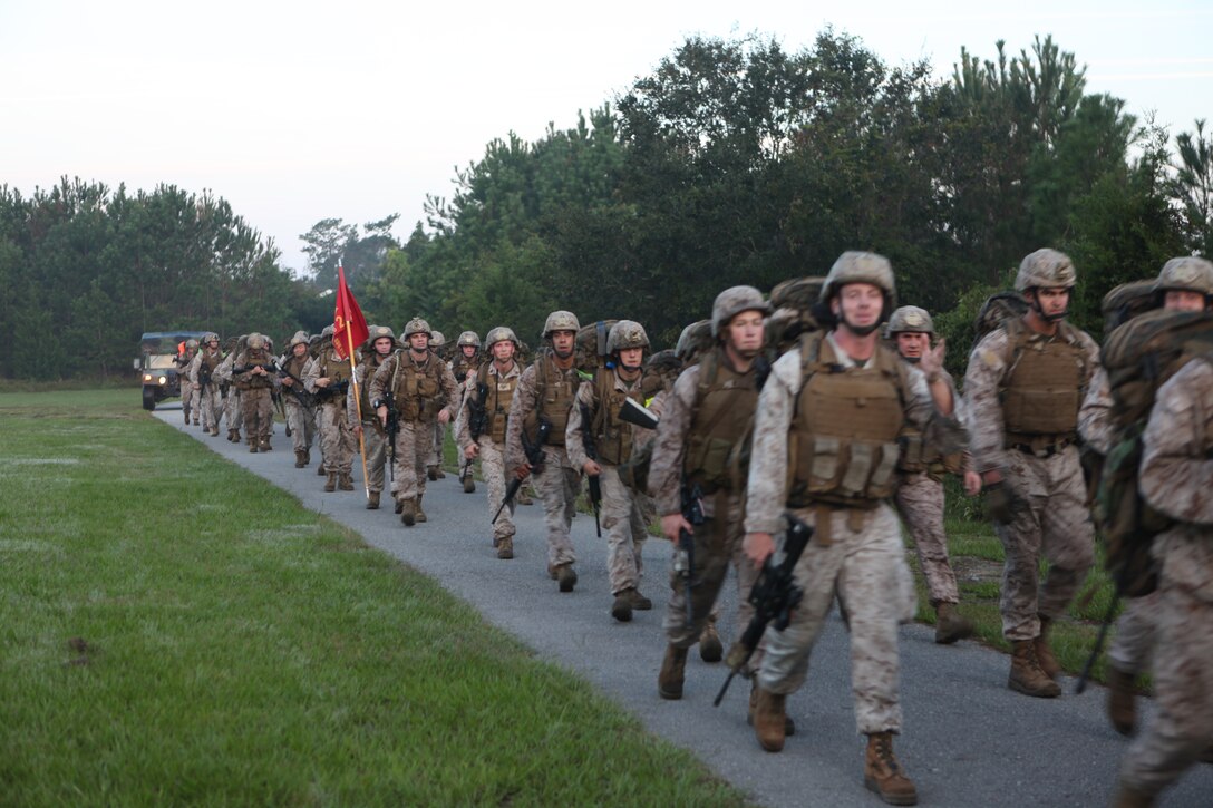 Marines with 2nd Air Naval Gunfire Liaison Company, II Marine Expeditionary Force Headquarters Group, II Marine Expeditionary Force, participate in a six-mile hike prior to attending an awards ceremony for nine Marines who were awarded a variety of medals for actions during their previous deployments.