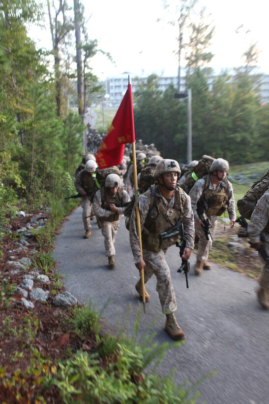 Marines with 2nd Air Naval Gunfire Liaison Company, II Marine Expeditionary Force Headquarters Group, II Marine Expeditionary Force, participate in a six-mile hike prior to attending an awards ceremony for nine Marines who were awarded a variety of medals for actions during their previous deployments.