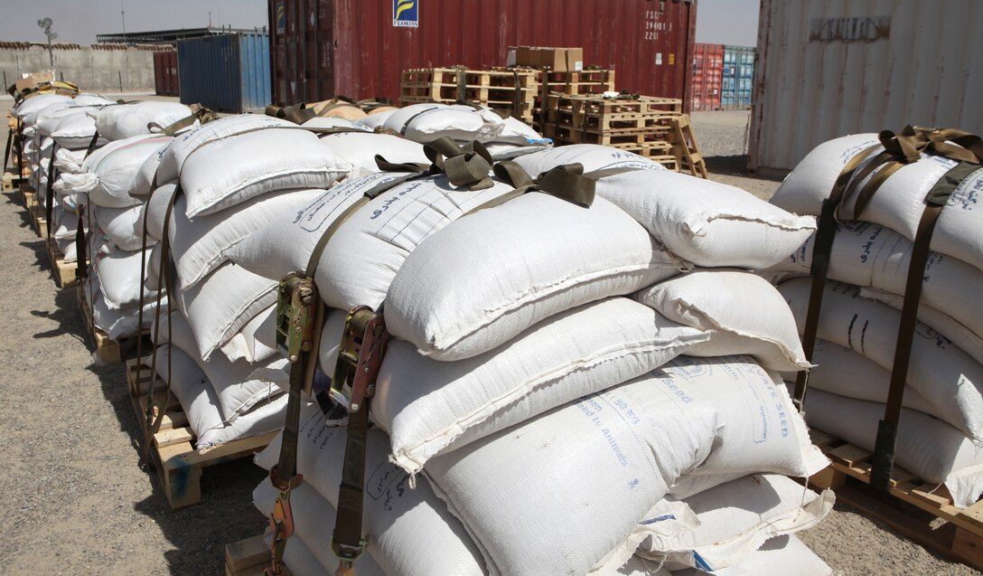 Ten pallets of wheat and vegetable seed and fertilizer are stacked on a flight line in Lashkar Gah, Afghanistan, before they are transferred to Kajaki, Sept. 30, 2011, where they will be distributed to local farmers.  Twenty-one metric tons will be distributed in Kajaki over the next several weeks as part of a livelihood stabilization movement in Helmand province.  (U.S. Marine Corps photo by Cpl. Katherine M. Solano)
