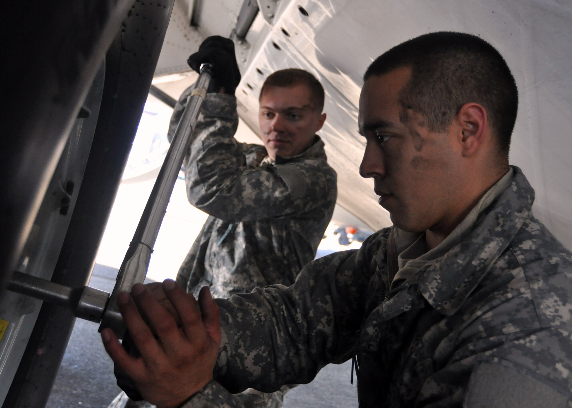 Airman 1st Classes Isaac Prieto, left, and Tommy Rasmus, both 62nd Aircraft Maintenance Squadron crew chiefs, work together tighten a bolt on a tire on a C-17 Globemaster III September 29, 2011, at Joint Base Lewis-McChord, Wash. (U.S. Air Force photo/Airman 1st Class Leah Young)