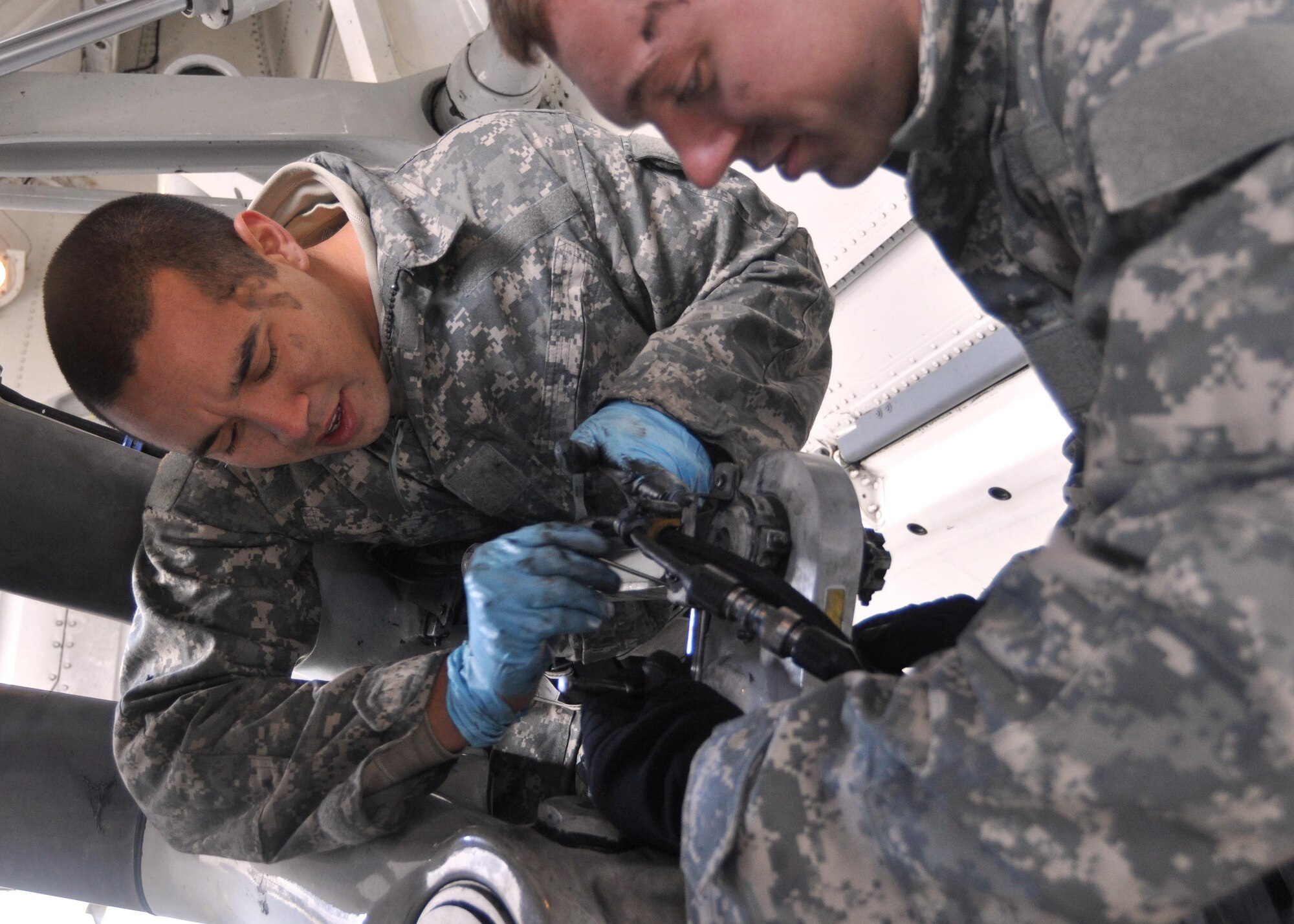 Airman 1st Classes Isaac Prieto, left, and Tommy Rasmus, both 62nd Aircraft Maintenance Squadron crew chiefs, work together to change the brakes on a C-17 Globemaster III September 29, 2011, at Joint Base Lewis-McChord, Wash. Tightening brakes is a task maintainers conduct quarterly.  (U.S. Air Force photo/Airman 1st Class Leah Young)