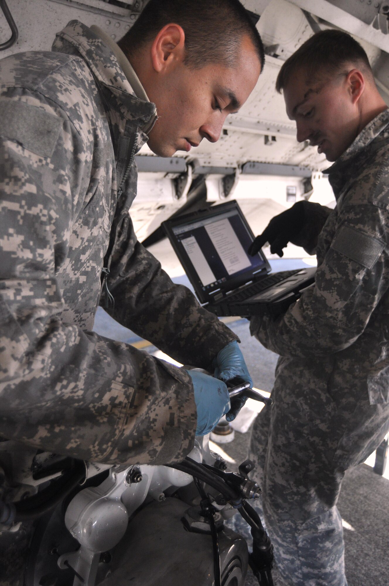 Airman 1st Class Tommy Rasmus, right, uses a Digital Technical Order System to provide Airman 1st Class Isaac Prieto instructions while changing brakes on a C-17 Globemaster III September 29, 2011, at Joint Base Lewis-McChord, Wash. Both Airmen are crew chiefs assigned to the 62nd Aircraft Maintenance Squadron, and perform routine maintenance on a daily basis. (U.S. Air Force photo/Airman 1st Class Leah Young)